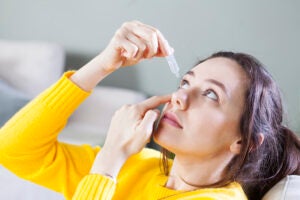 young woman applying eye drop