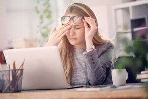 Young tired working woman at work