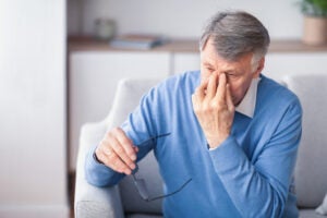 Elderly Man Massaging Nosebridge