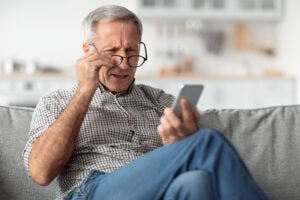 Senior Man Squinting Reading