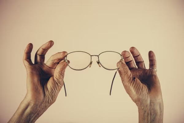 Man holding pair of glasses