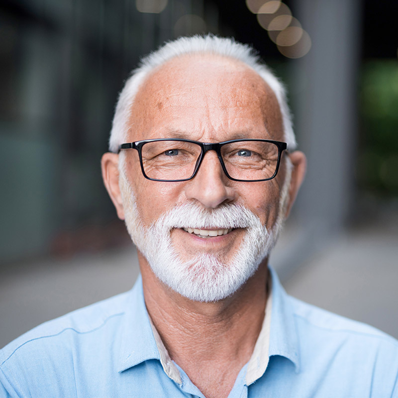 mature man smiling with glasses on