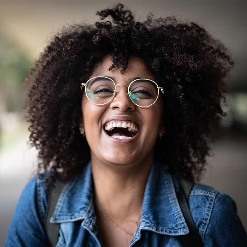 woman smiling with mouth open and thin frame glasses on
