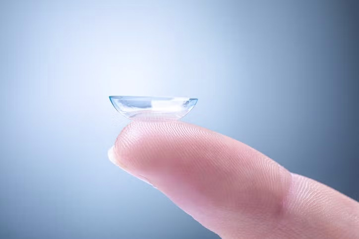 Person holding eye lens