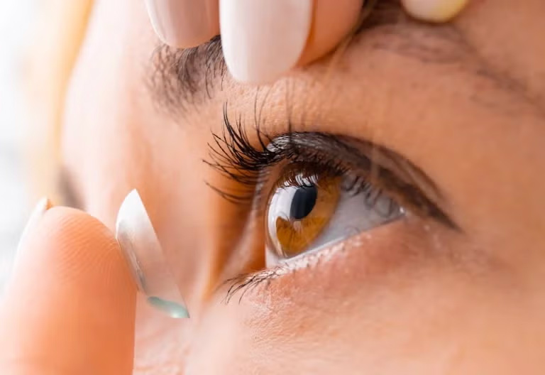 Women applying her contact lenses