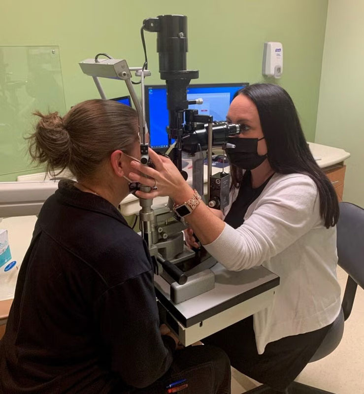 an eye doctor checking a woman's eye