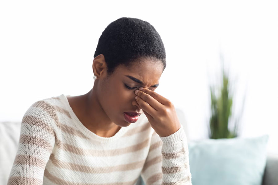 a woman holding near her eye in pain