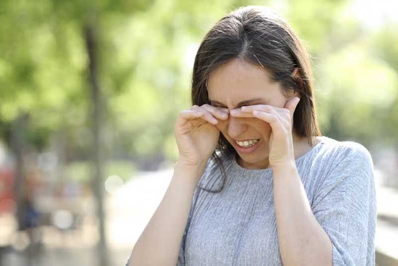 woman rubbing eyes
