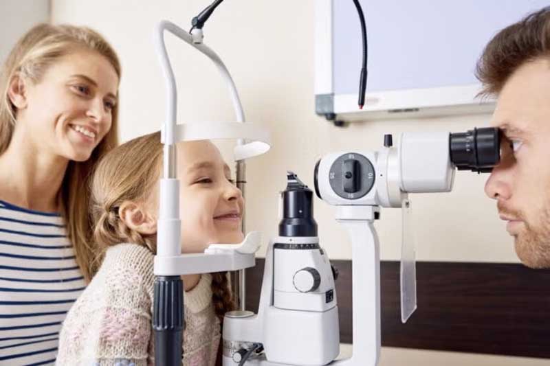 doctor checking small girls eyes