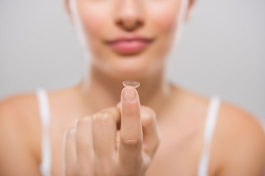 a woman holding eye lens on her finger tip