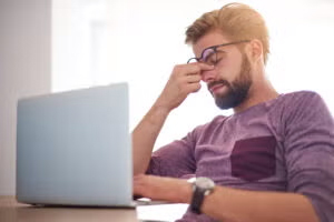 Man working on laptop with stress