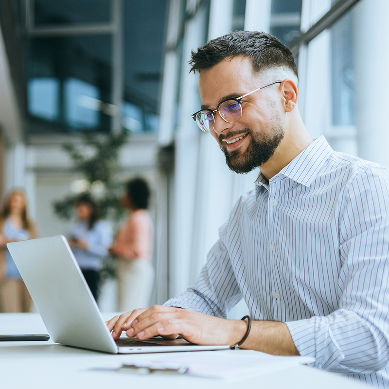 man wearing glasses while working on a computer