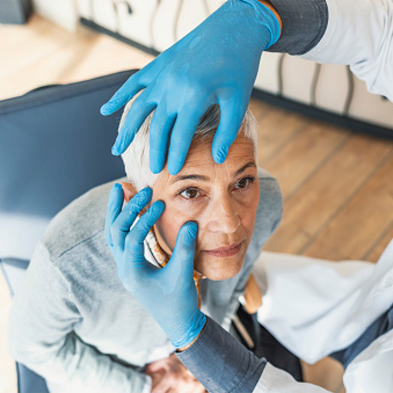 mature woman getting eyes looked at by doctor