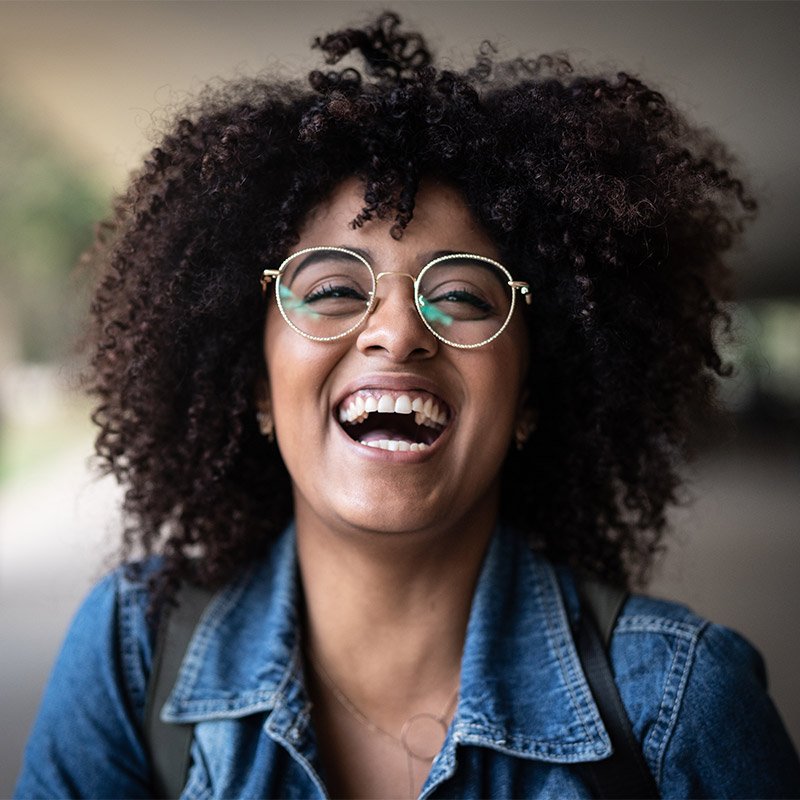 Woman smiling and laughing while wearing glasses in Derry, NH, and Nearby Areas